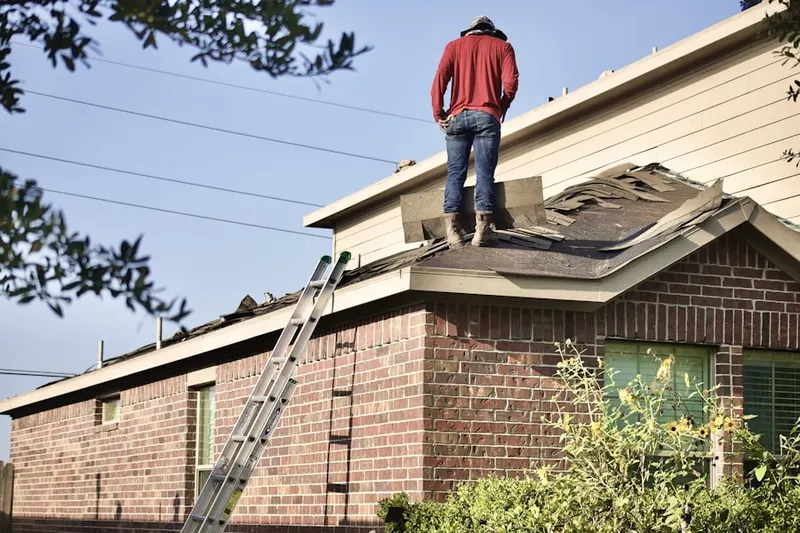Professional roofer working on a residential roof in Port Washington